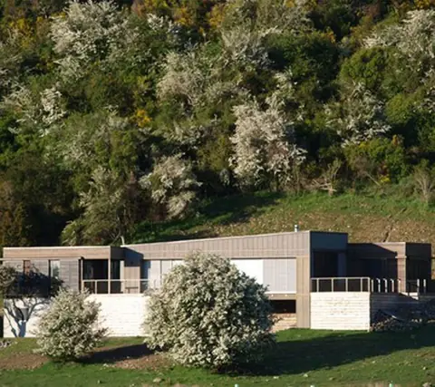Single-level home with timber and stone cladding set against native bush