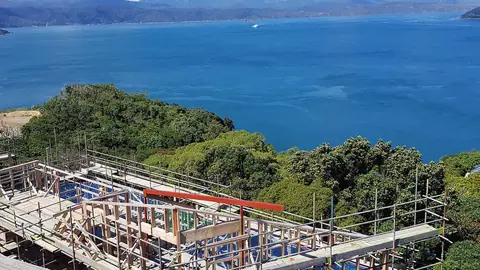 Timber framing and scaffolding on a hillside build overlooking the harbour